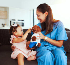 Female Nurse holding toy and a girl